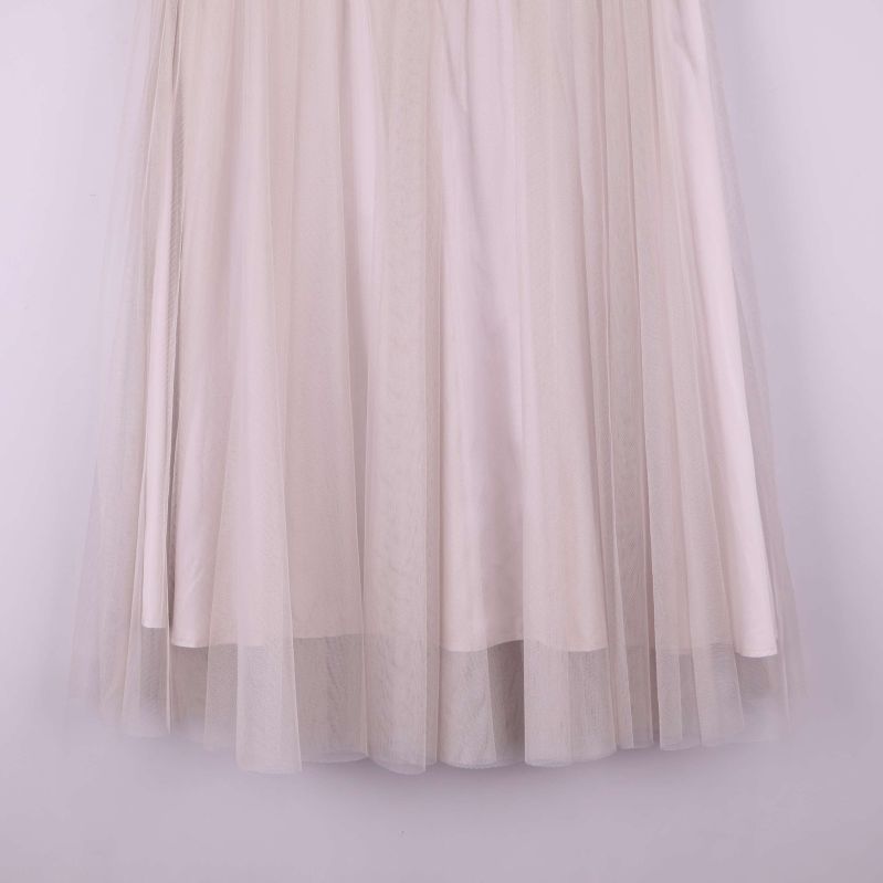 Närbild på nedre delen av kjol med flera lager ljus tyll