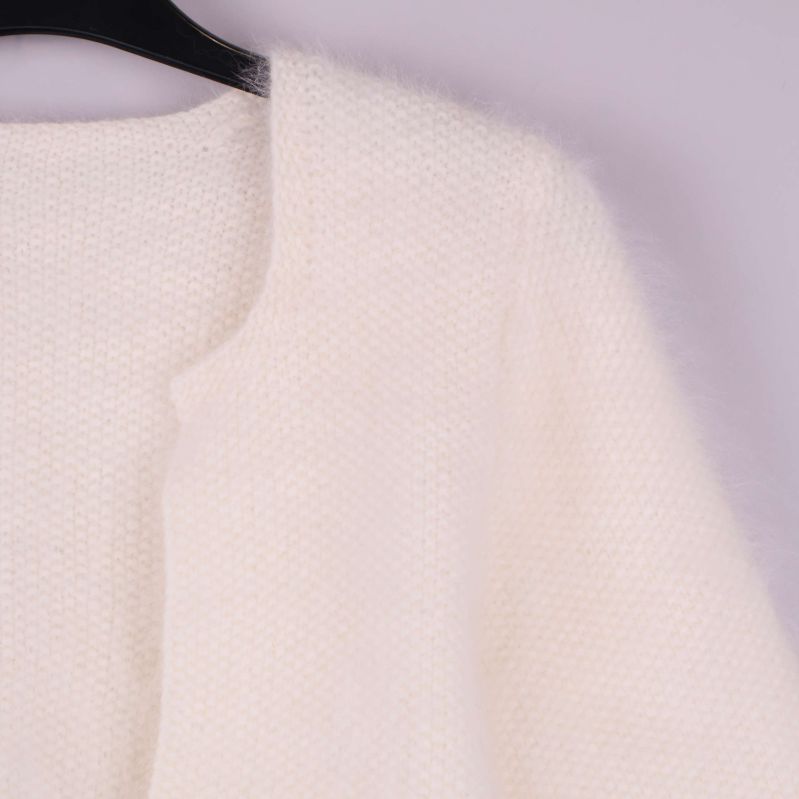 Närbild av koftans stickade material och öppen front