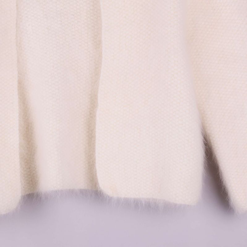 Närbild på koftans nederkant med mjuka fibrer