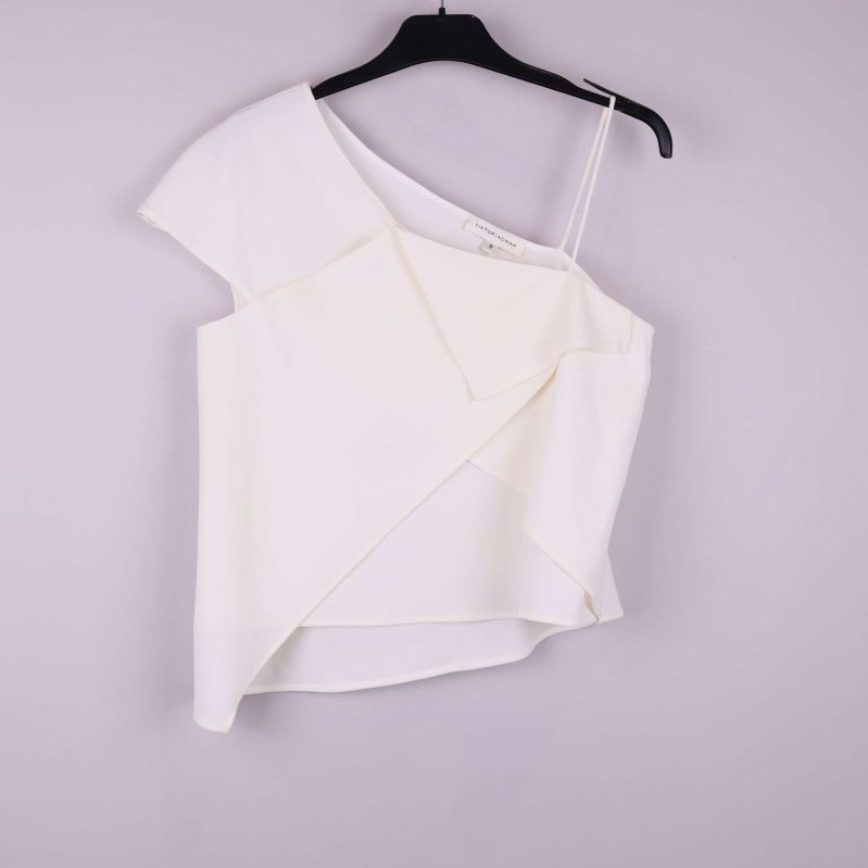 Asymmetrisk vit topp med axelband och omlottdetaljer framifrån