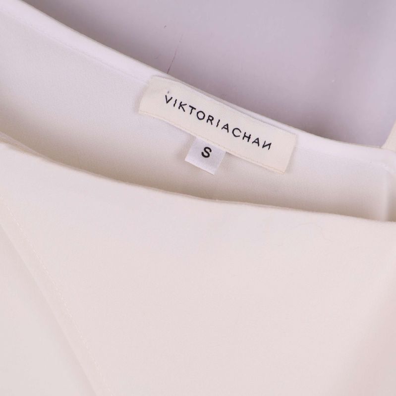 Närbild på etikett med texten VIKTORIACHAN och storlek S