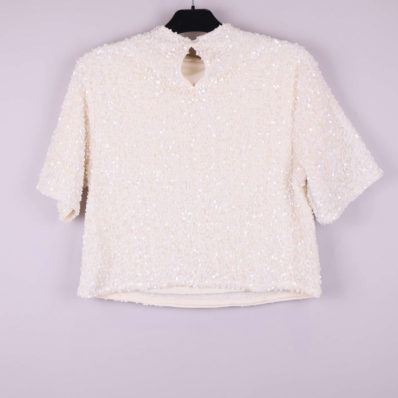 Paljettopp bakifrån med knappdetalj och rundad öppning