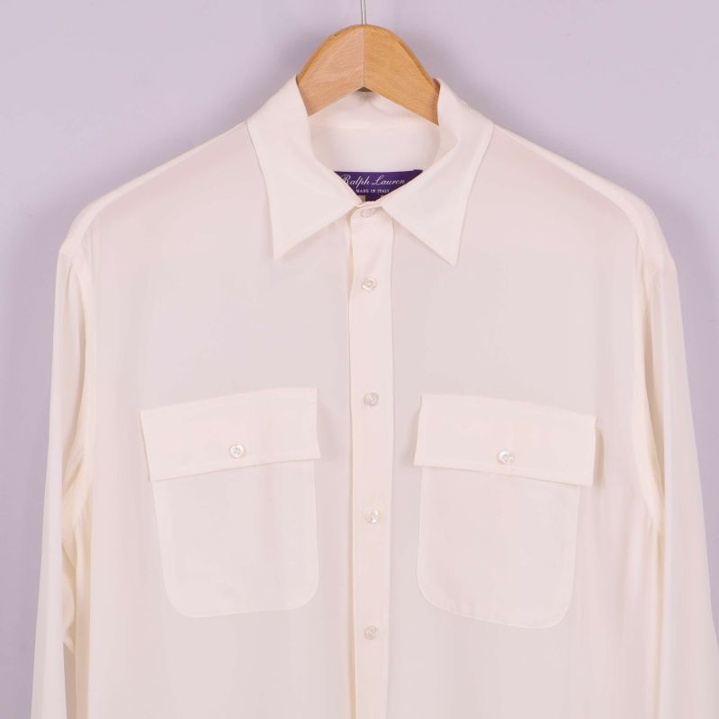 Närbild på framfickor och knappar på vit blus