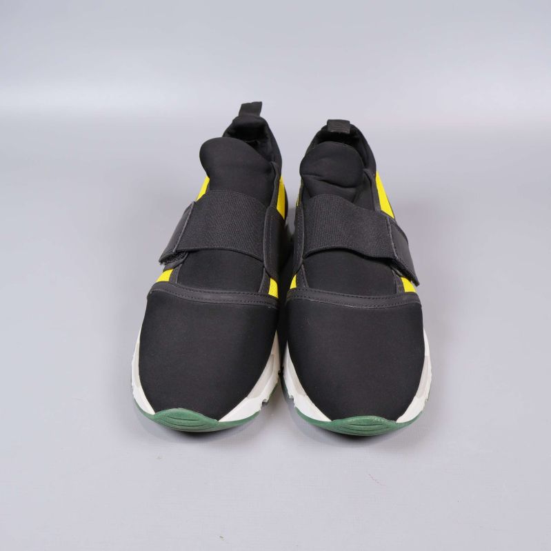 Sneakers framifrån med detaljer i svart och gult