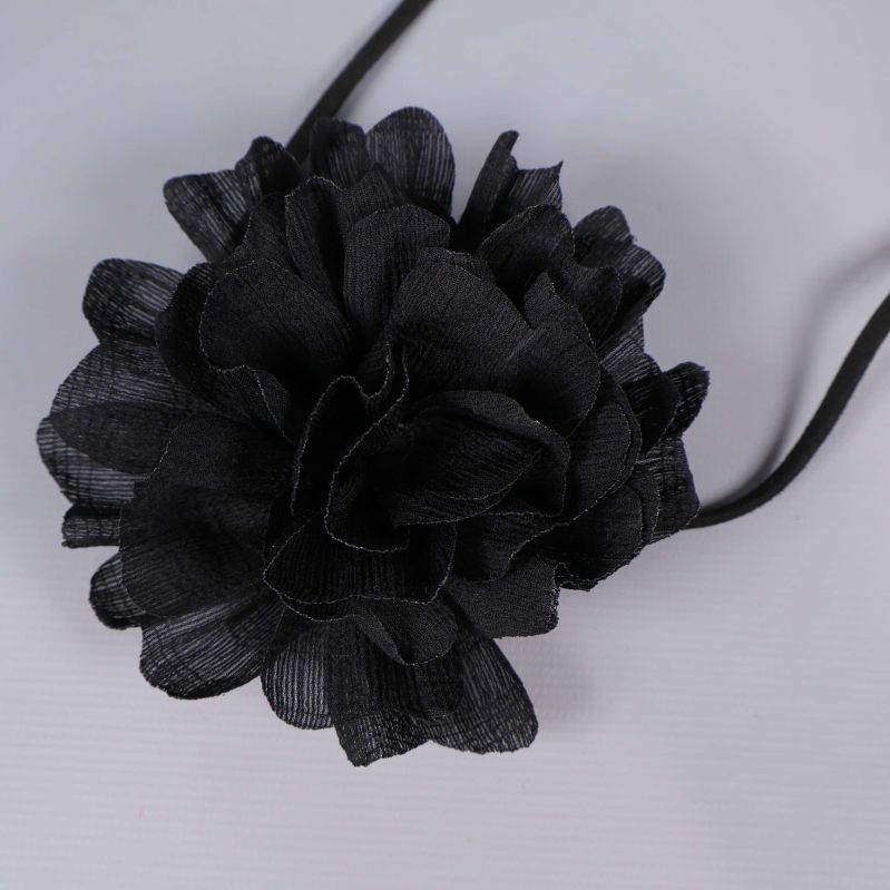 Närbild på svart tygblomma med textur