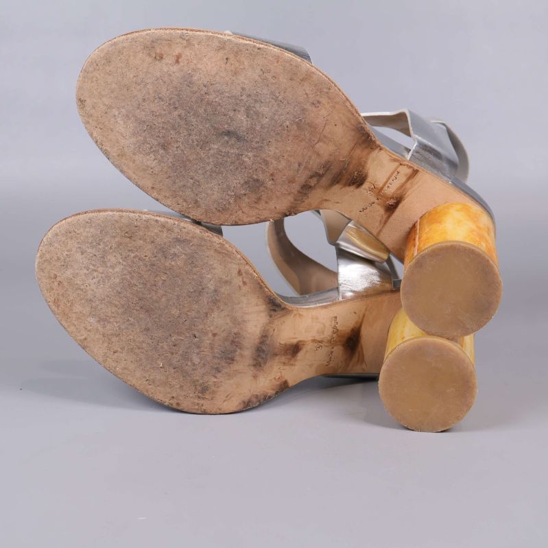 Undersida av sandaler visar slitage på sulan