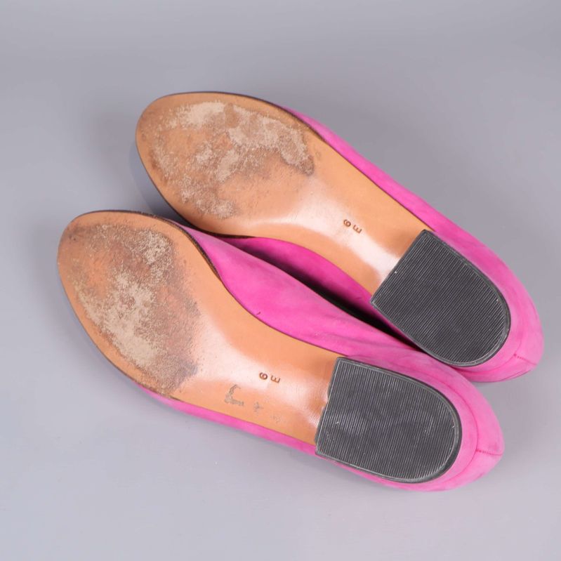 Slitna yttersulor på rosa ballerinas visas underifrån