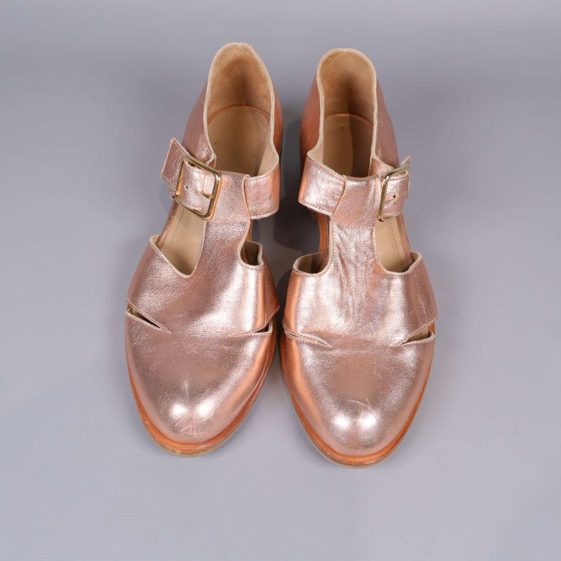 Ovandelen av par metallicfärgade sandaler med spännen