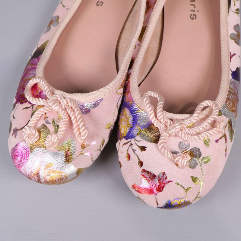 Närbild på tåpartiet av ballerinaskor med dekorativa rosetter och blommönster
