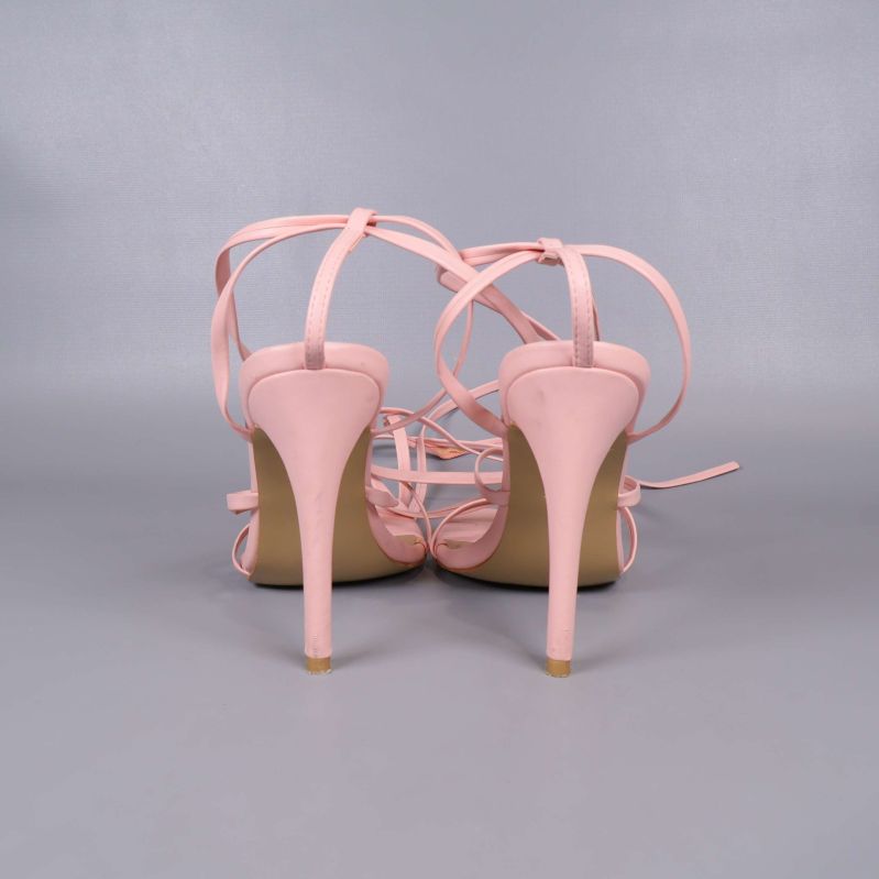 Baksidan av sandaler med rosa snörning och stiletthäl