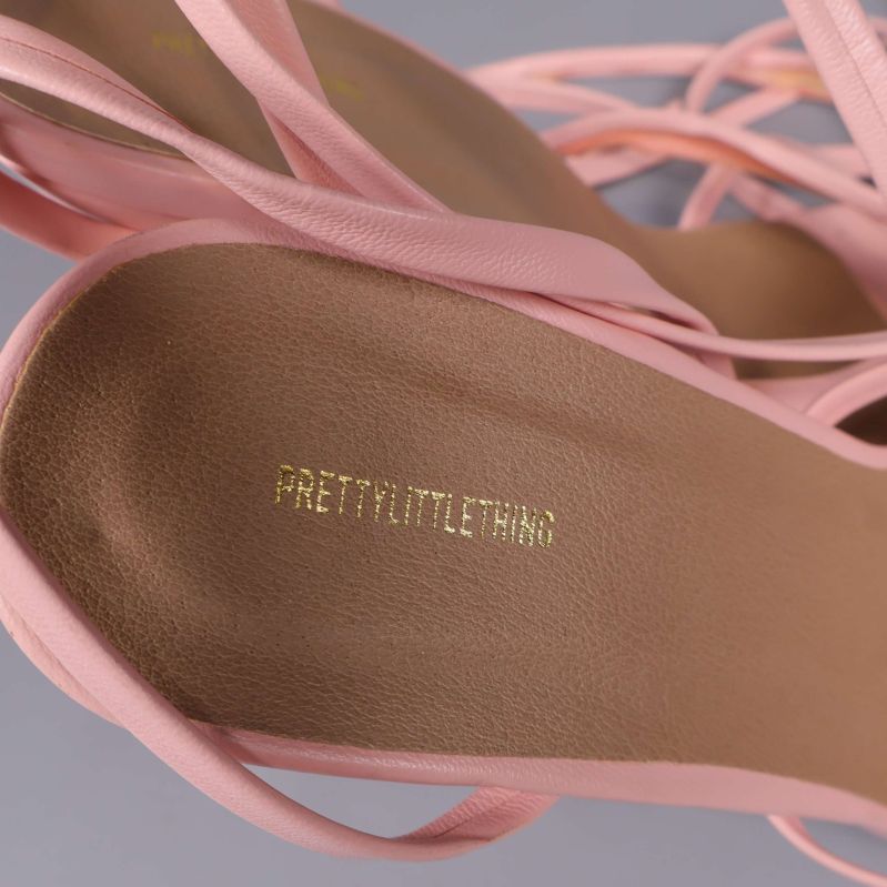 Närbild på innersula med texten PRETTYLITTLETHING i guld