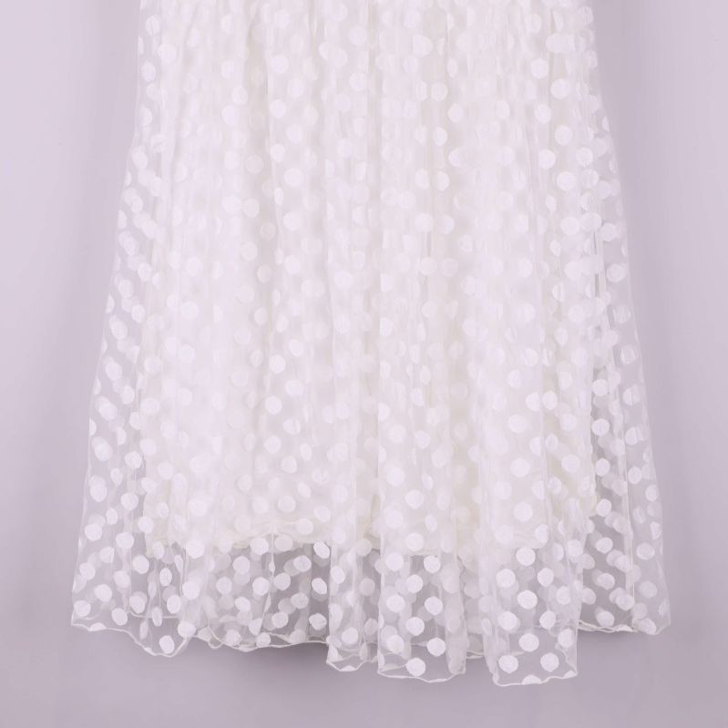 Nedre del av vit lång kjol med prickigt strukturmönster