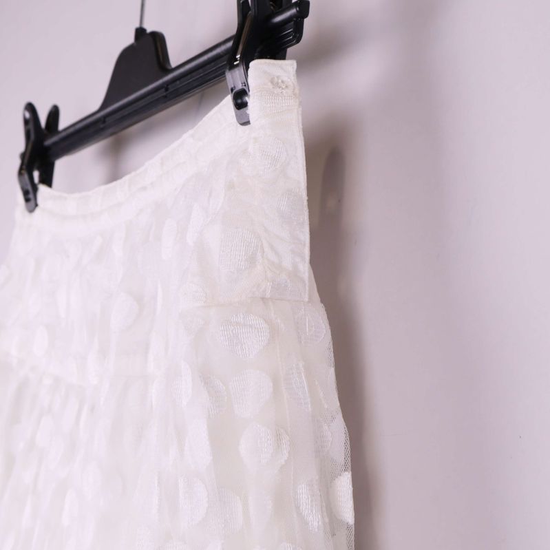 Närbild på midja och sida av vit kjol