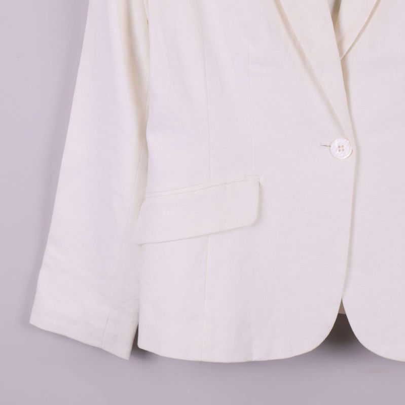 Närbild på ficka och ärm nedtill på vit kavaj