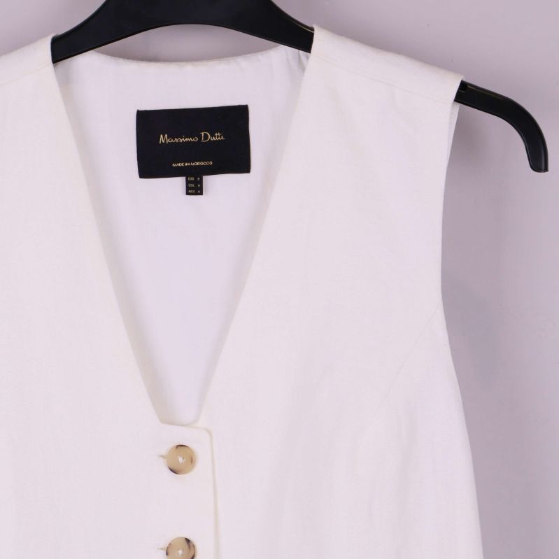 Närbild på västens axelparti och knappar