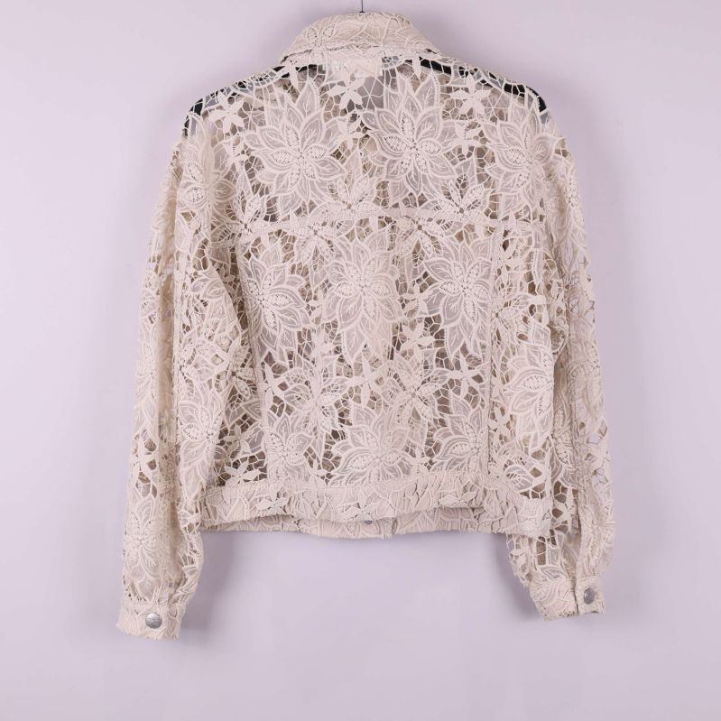 Spetsjacka med blommönster bakifrån på galge