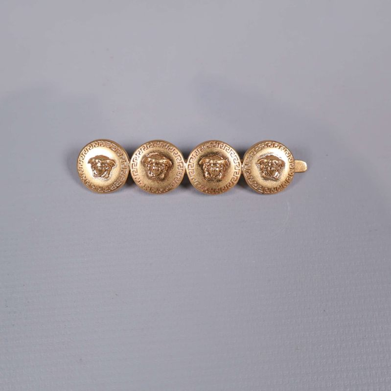 Hårspänne i guld med fyra dekorerade runda emblem