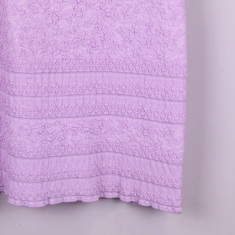 Närbild på nederkanten av tunikan med tydlig struktur och mönster