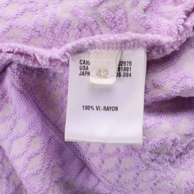 Materialetikett med texten 100% Rayon i ljuslila tunika