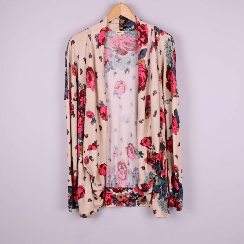 Framsidan av beige kaftan med blommönster på galge