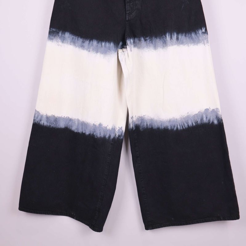 Närbild på ben och batikmönster på jeans
