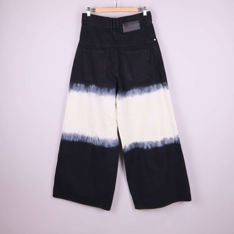 Baksidan av vida jeans med batikmönster och Balmain-lapp