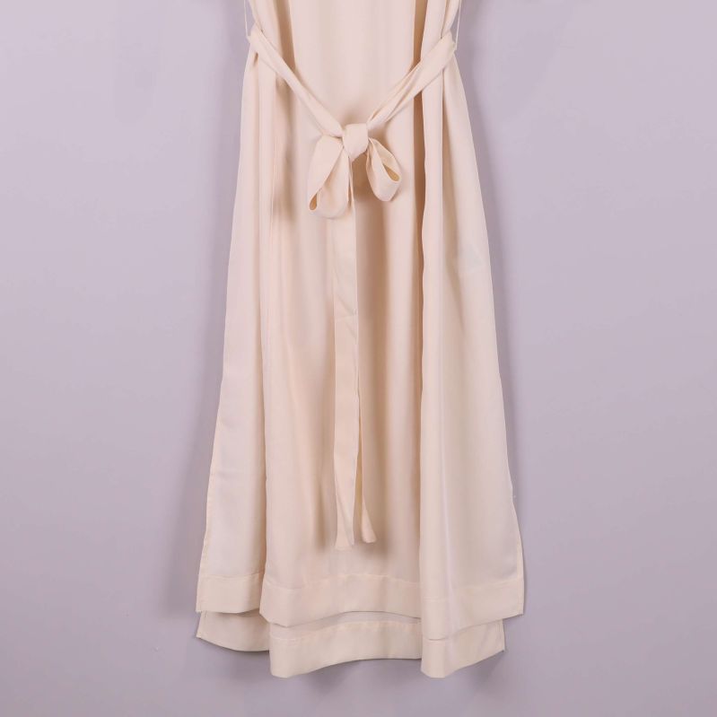 Närbild på klänningens nedre del och skärp