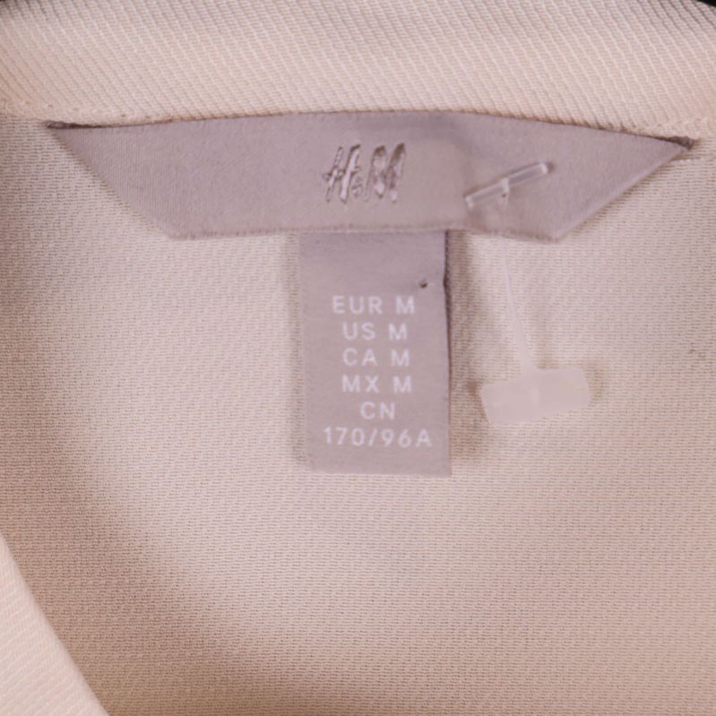 Närbild av H&M-märkesetikett och storlekslapp