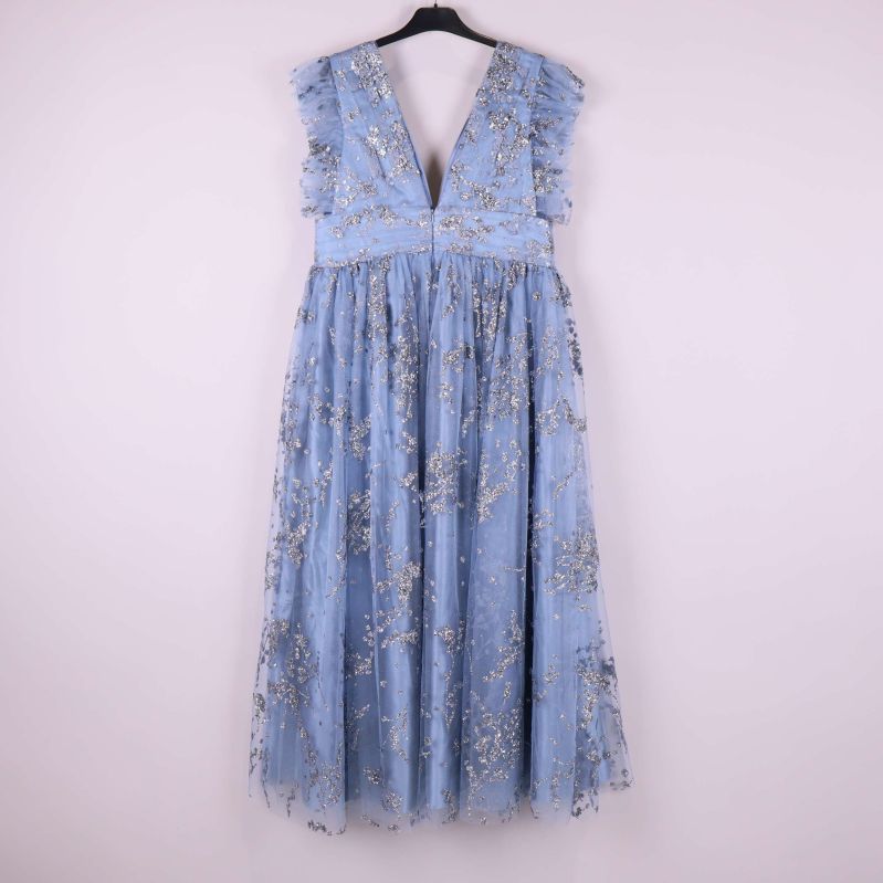 Ljusblå klänning med glitterdetaljer bakifrån på galge