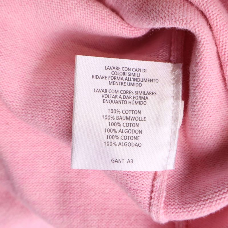 Materialetikett visar 100% bomull på flera språk