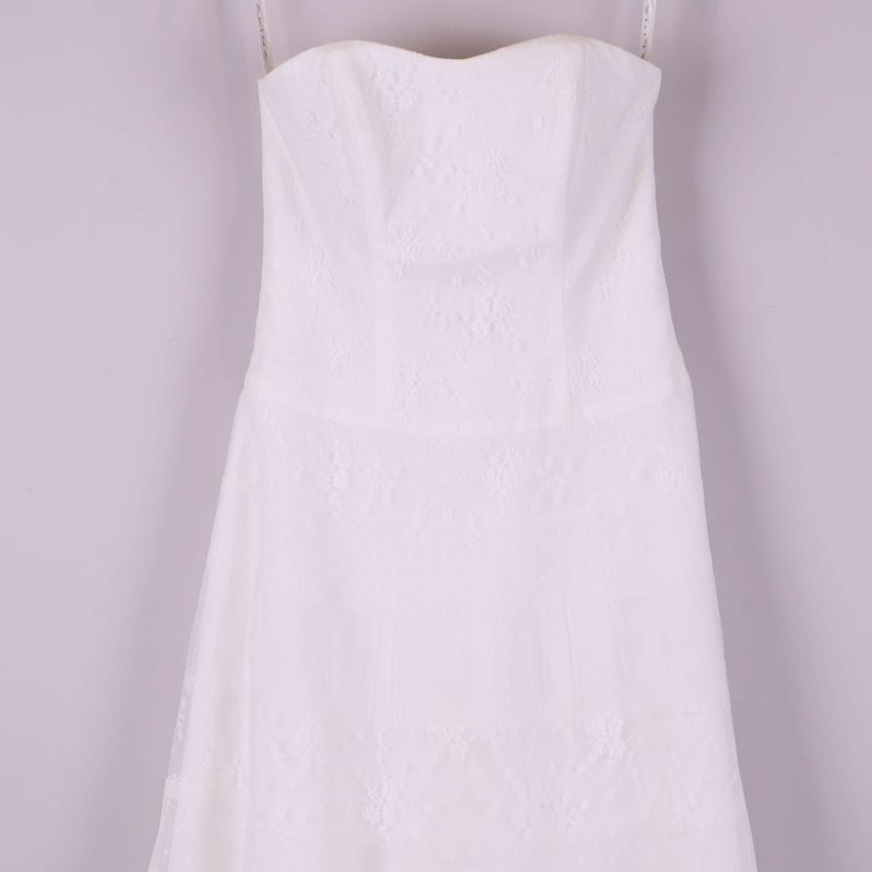 Ovandelen av vit axelbandslös spetsklänning