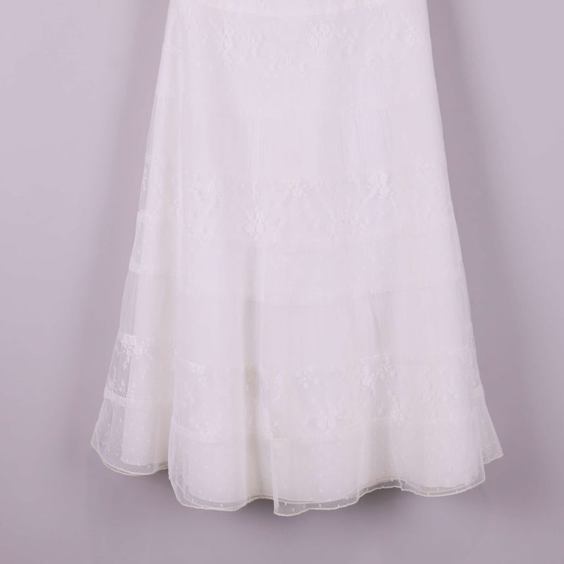 Nederdel av vit klänning med spetsmönster