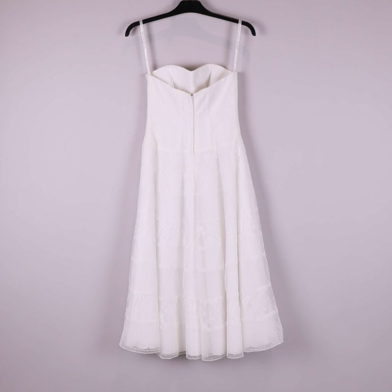 Baksida av vit axelbandslös klänning med dragkedja