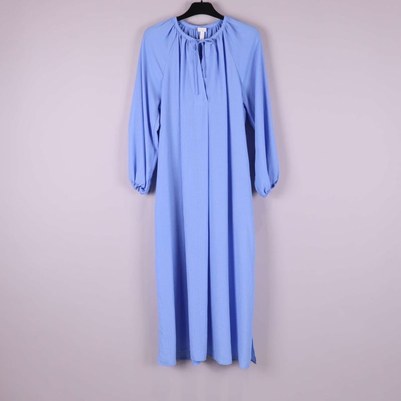 Ljusblå långklänning med långa ärmar på galge