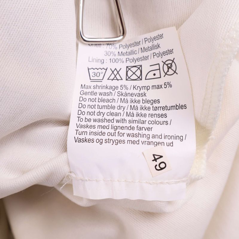 Tvättlapp som visar material: polyester och metallisk tråd