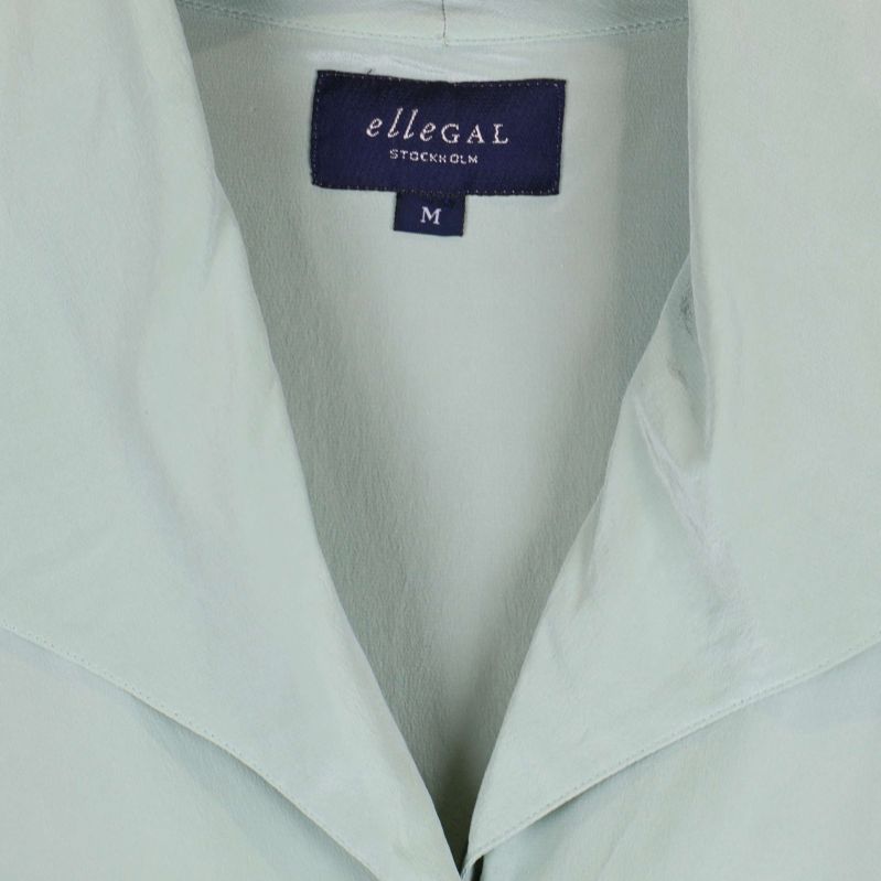 Närbild på etikett från ellegal Stockholm på skjortan