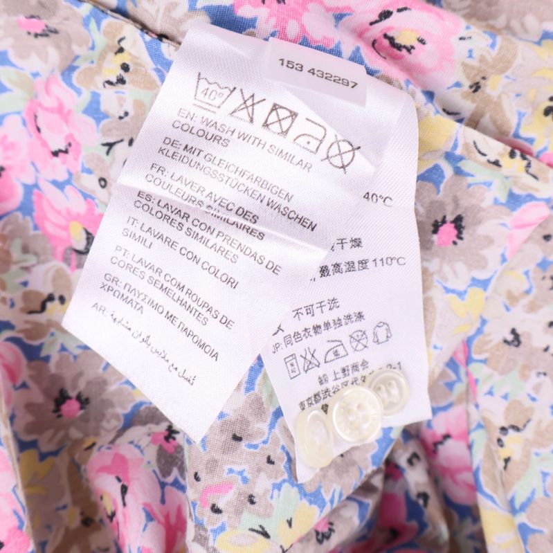 Tvättetikett i skjorta visar tvättråd och extra knappar