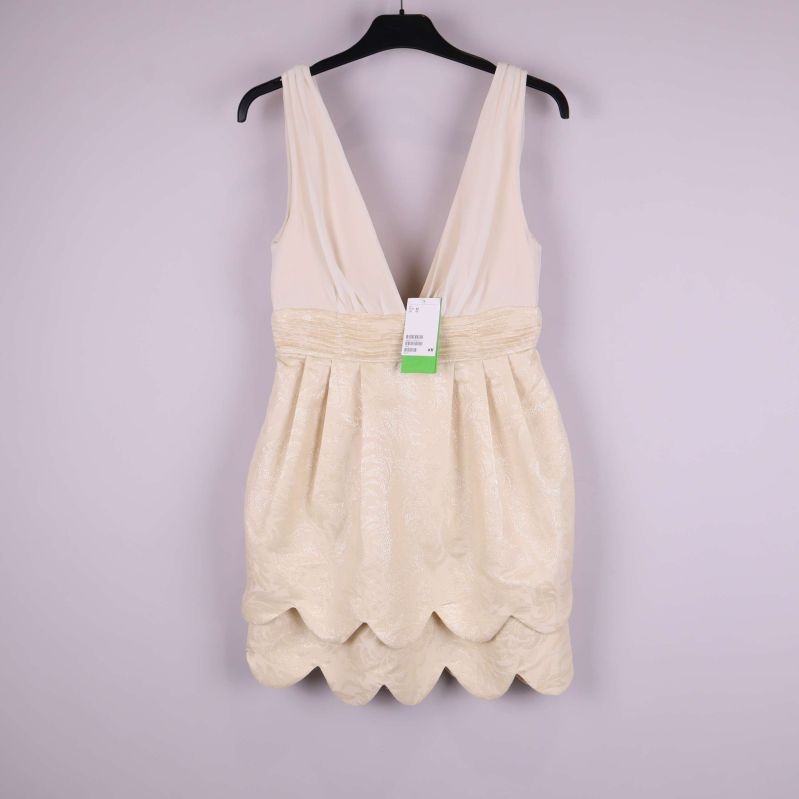 Elegant ljus klänning med djup v-ringning och scallop-kant