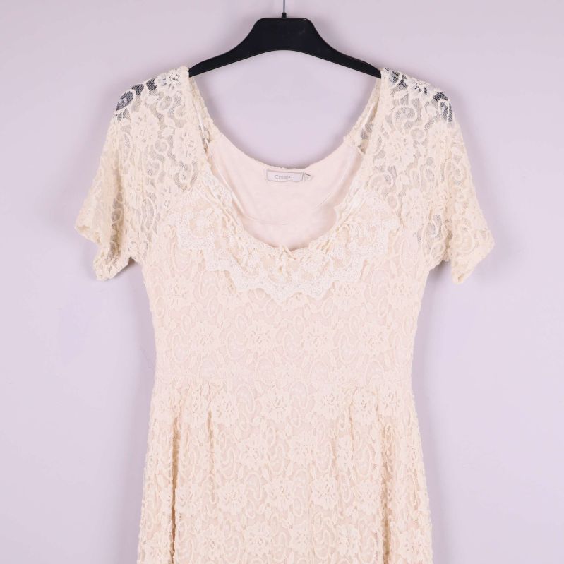 Övre delen av naturvit spetsklänning med rundad hals