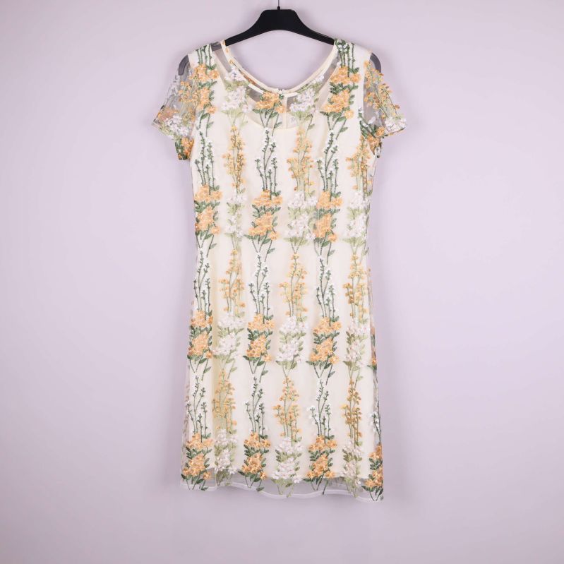 Helbild av ärmlös klänning med blommiga broderier framifrån