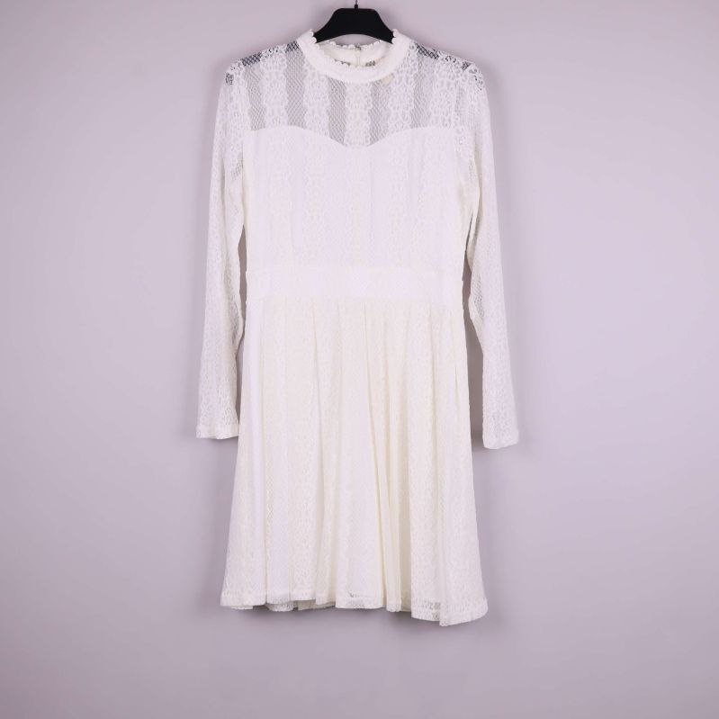 Vit spetsklänning med lång ärm fotograferad framifrån