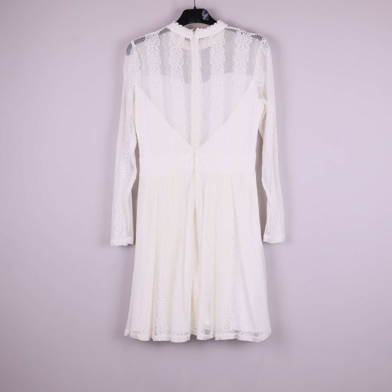 Vit spetsklänning fotad bakifrån med synlig dragkedja