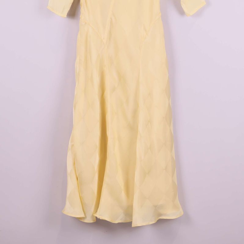 Kjoldel på lång gul klänning med rutstruktur i tyget