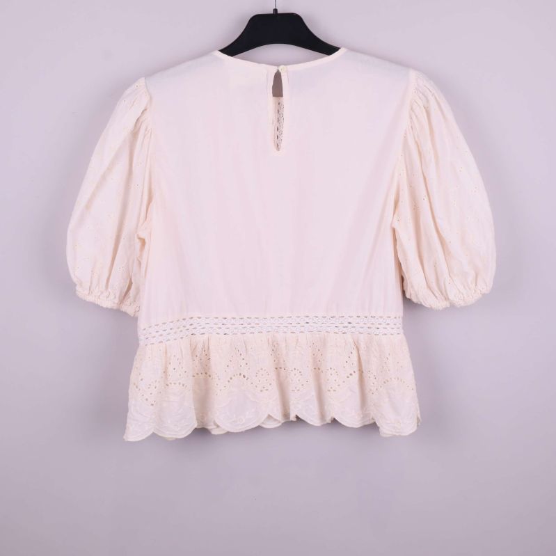 Krämvit broderad blus upphängd bakifrån