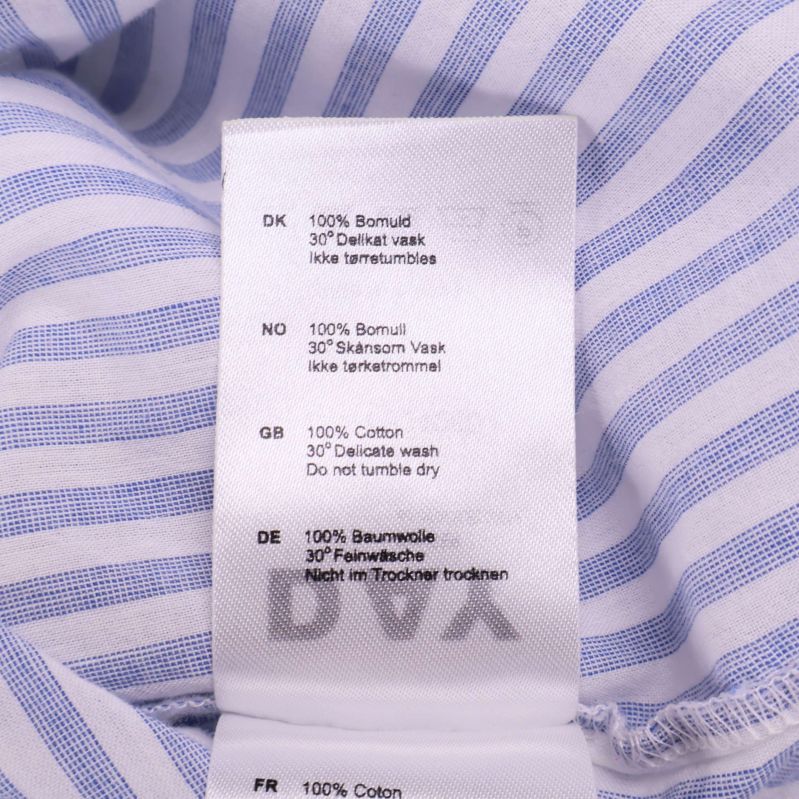 Materiallapp visar 100% bomull på flera språk