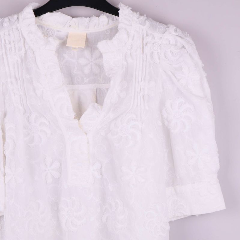 Närbild av broderi, hals och axlar