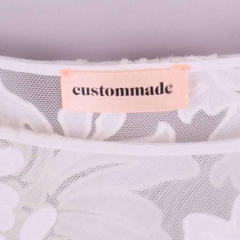 Närbild på rosa etikett med texten custommade