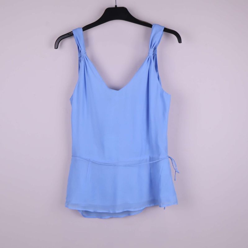 Baksidan av ljusblå ärmlös topp på galge