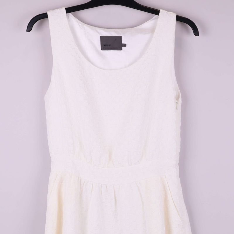 Övre del av vit ärmlös klänning med struktur