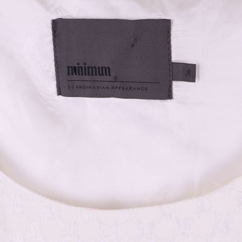 Närbild av Minimum etikett i nacken på klänning